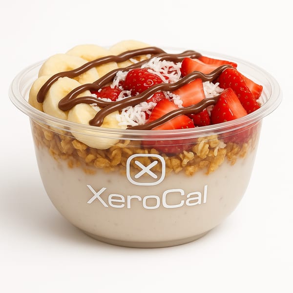 Xerocal acai bowl with bananas, strawberries, shredded coconut, chocolate drizzle, and granola.