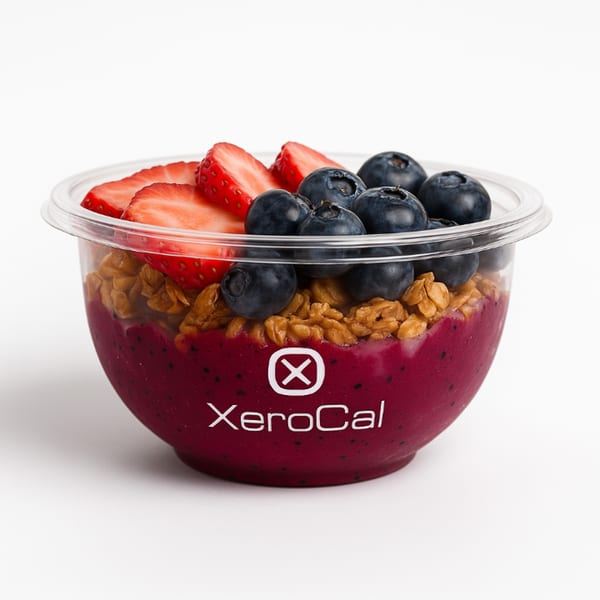 Xerocal acai bowl with granola, blueberries, and sliced strawberries in a clear plastic container.
