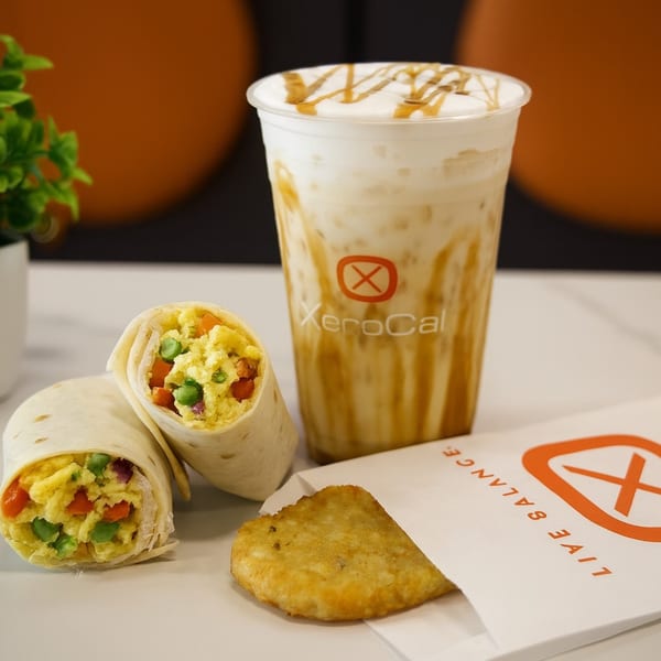 Xerocal breakfast with two wraps, a hash brown in a branded bag, and a caramel iced coffee.